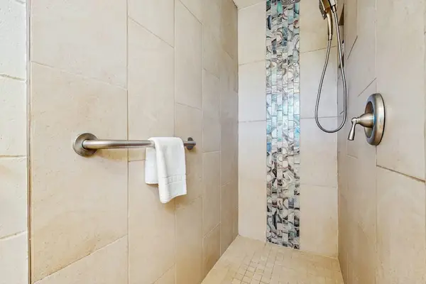 Refresh in the walk-in shower featuring stylish tile accents and modern finishes.