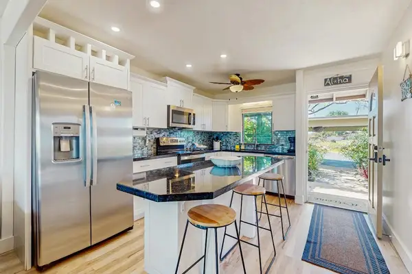 The fully equipped kitchen features modern appliances and a convenient breakfast bar.