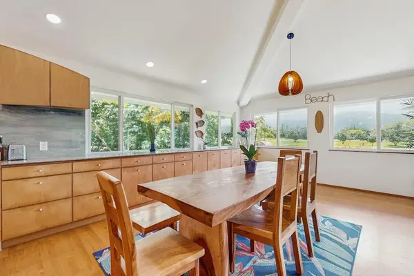 Mid-century modern open-concept kitchen and dining area featuring warm wood finishes and expansive windows