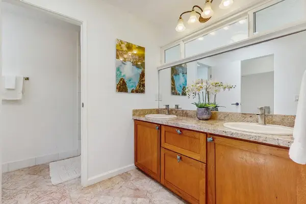 Bathroom featuring a long, wood-grained vanity cabinet