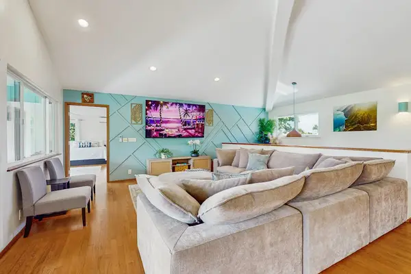 Contemporary living room featuring a prominent, wrap-around beige sectional sofa that maximizes seating space.