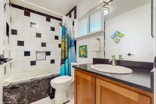 Modern bathroom with dark marble-style countertops and a vanity