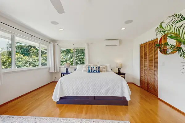 Bright bedroom features a spacious layout with a tropical aesthetic
