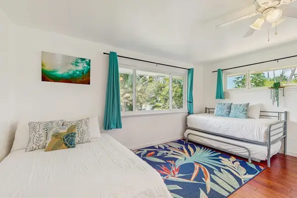 Coastal-themed bedroom featuring three beds and a vibrant color scheme.