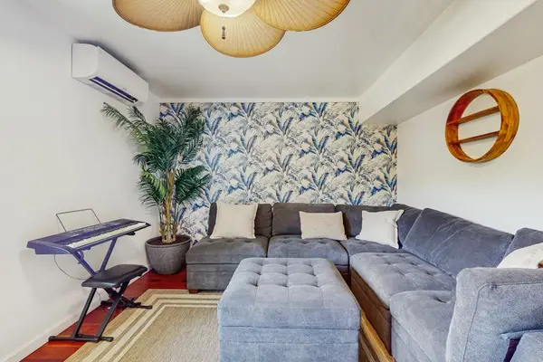This cozy corner of the rec room features a large gray sectional sofa and a matching ottoman