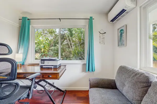 Compact home office setup featuring a dark wooden desk with an ergonomic mesh office chair