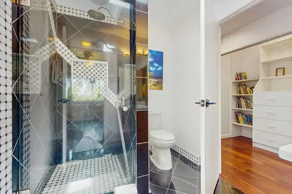 A glass-enclosed walk-in shower is designed with a modern, contemporary aesthetic