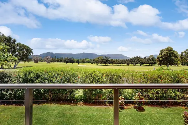 A scenic view of a field and mountains from the rustic balcony