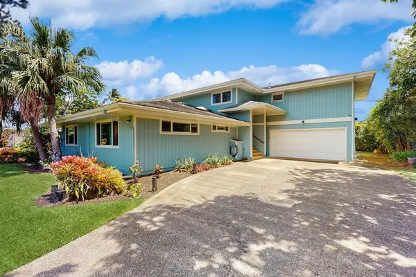 A prominent two-car garage and landscaped yard.