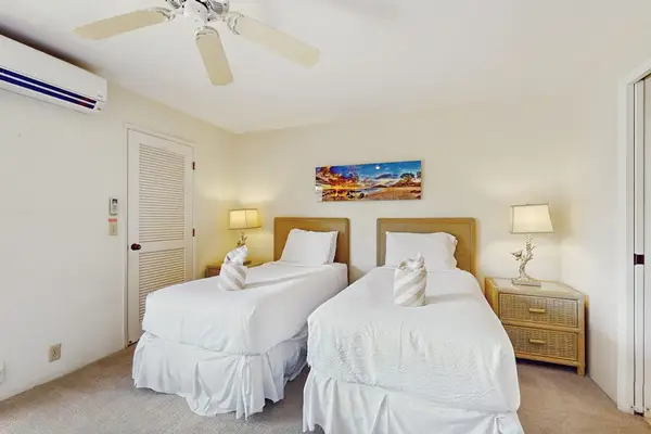 Second Bedroom twin beds rest beneath ceiling fan and artwork