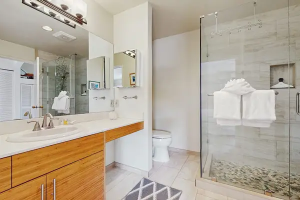 Full Bathroom showcases glass shower bright vanity and white finishes