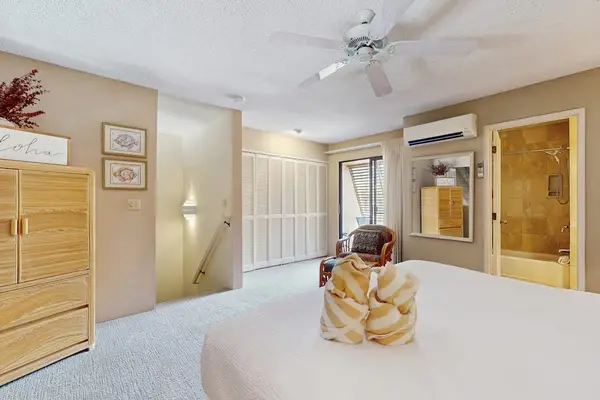 Opens toward balcony with bedding and ceiling fan