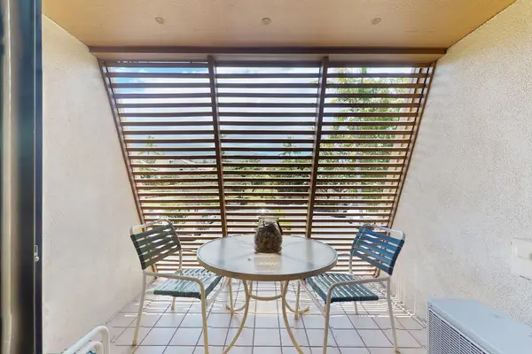 Covered patio dining offers shaded seating beneath palms and greenery