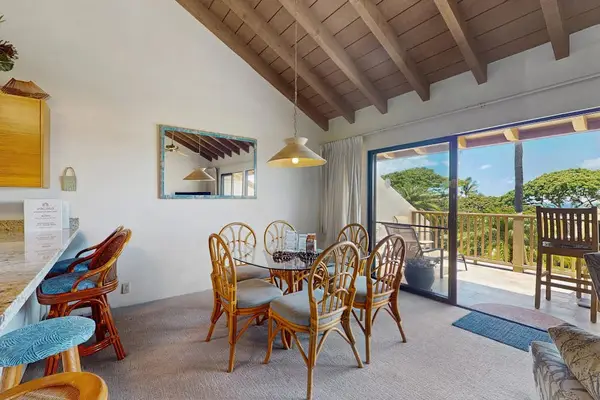 Rattan dining table welcomes meals beside kitchen and garden views