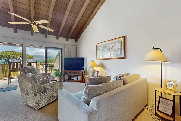 Living room seating frames garden views beneath wood ceiling beams