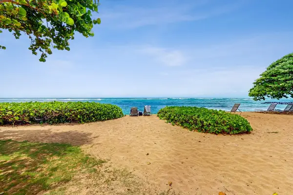Crystal-clear turquoise waters gently wash onto pristine white sandy beaches.