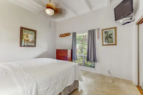 Cozy Secondary Bedroom featuring Tropical Decor, TV & Natural Light
