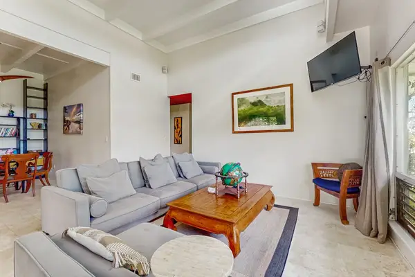 Bright Open-Concept Living Area with High Vaulted Ceilings & Wall TV