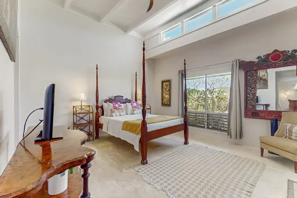 Elegant Primary Bedroom Suite with Four-Poster Bed & High Ceilings.