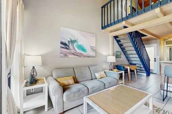 Open living space offers sofas, dining access, and ocean views