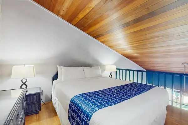 Peaceful sleeping area showcases a bed, blue linens, and artwork