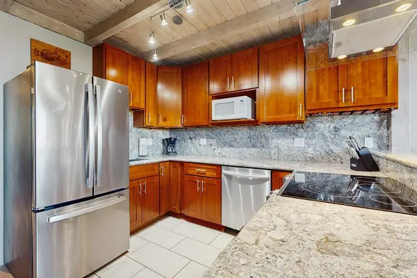 Warm kitchen showcases granite counters, practical storage, and updated appliances