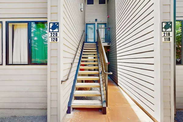 Exterior staircase leads toward the home through bright coastal surroundings