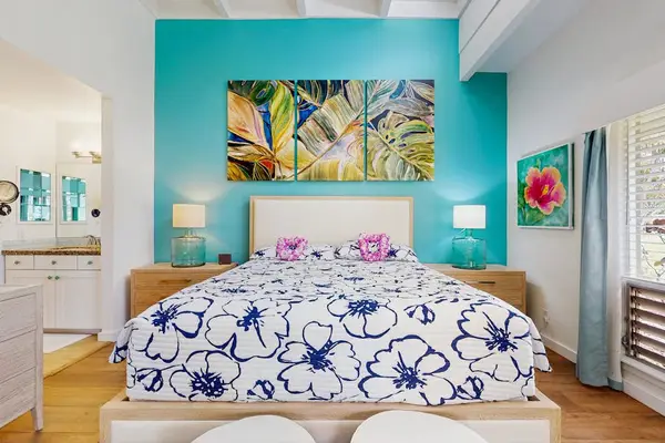 Airy bedroom presents a restful bed, soft textures, and thoughtfully arranged furnishings.