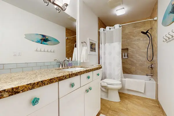 Refreshing bathroom features a modern vanity, sleek fixtures, and tiled walls throughout.