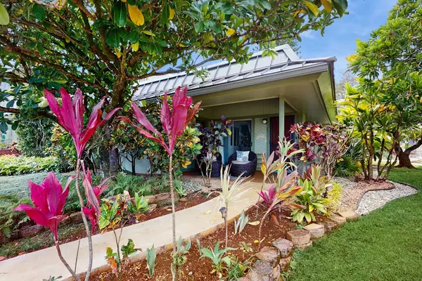 Well-kept exterior presents charming character, clear walkways, and surrounding greenery