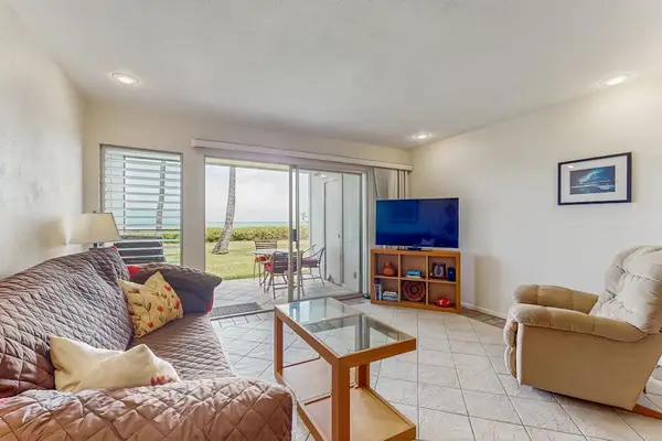 Living room features sofa, armchairs, television, coffee table, and windows