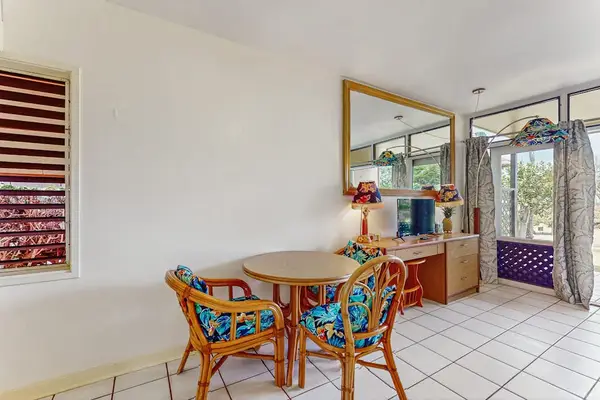Dining area offers table, colorful chairs, windows, and garden access