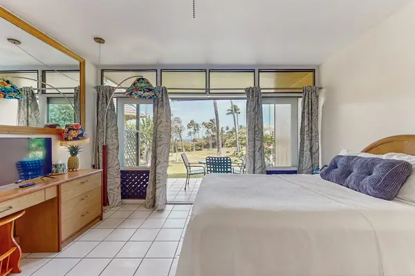 Studio sleeping area includes queen bed, television, dresser, and views