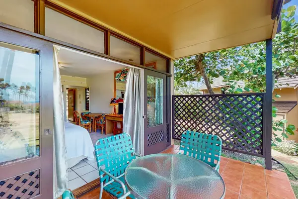 Patio seating opens toward landscaped grounds through wide sliding doors
