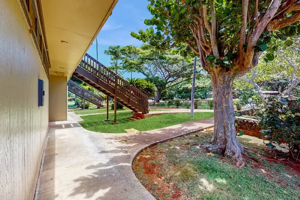 Resort pathway passes lawns, shade trees, stairways, and building entrances