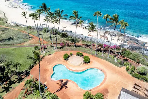 Aerial pool view shows beach, palms, lawns, pathways, and buildings