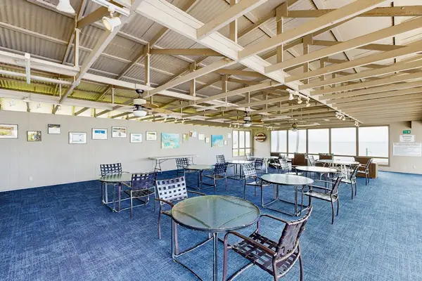 Covered outdoor dining area provides tables, chairs, fans, and views