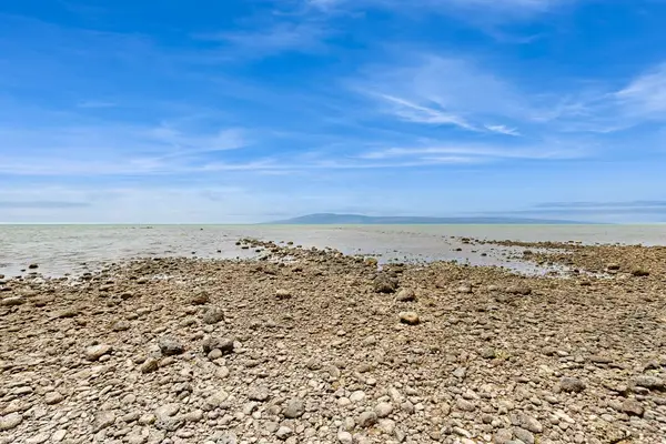Rocky shoreline stretches beneath broad skies near the resort grounds