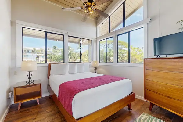 Bright primary bedroom with tropical views