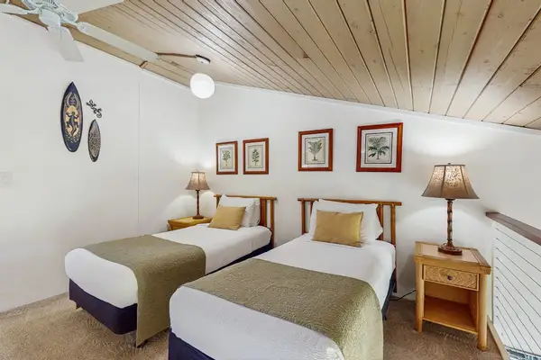 Two twin beds located in the loft as it overlooks the living room below with this open air fill.