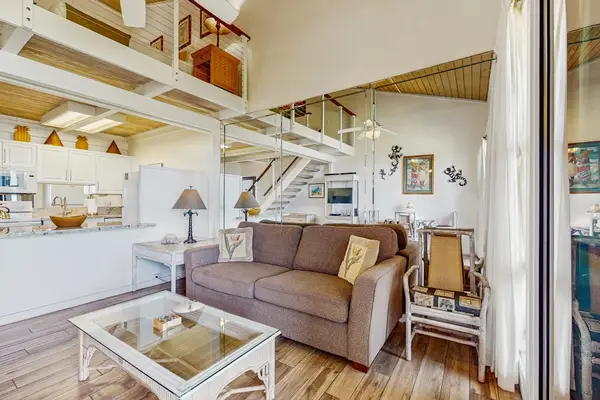 Lovely living room open to the loft above with lots of natural light streaming in from the lanai.