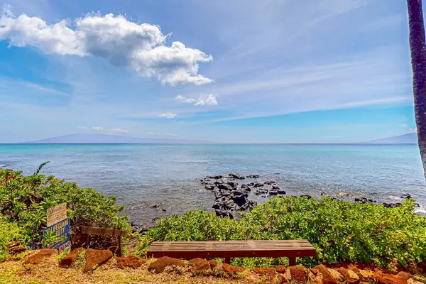 Coastal lawn overlooks rocky shoreline, turquoise water, and tropical horizons