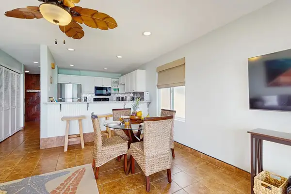 Dining room with seating for four and extra seating at the barstools at the kitchen counter.