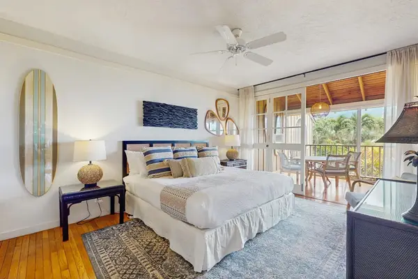 Airy bedroom with balcony access welcomes natural light and refreshing island breezes inside