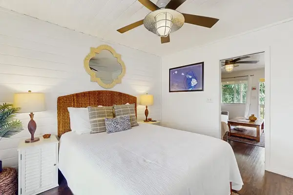 Inviting Bedroom with Woven Headboard, Nightstands & View to Living Room