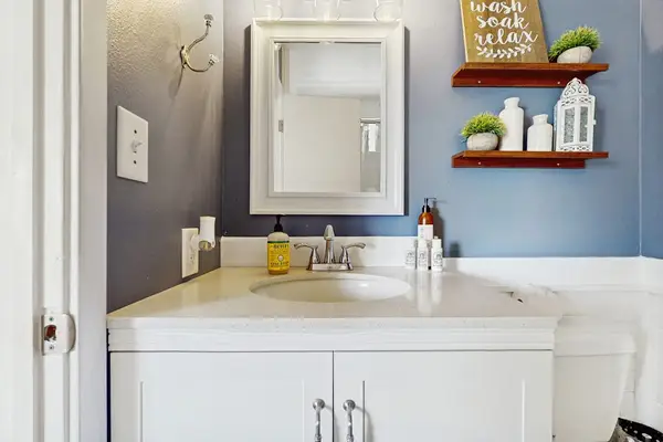 Clean Bathroom Vanity with White Cabinets & Floating Wall Shelves