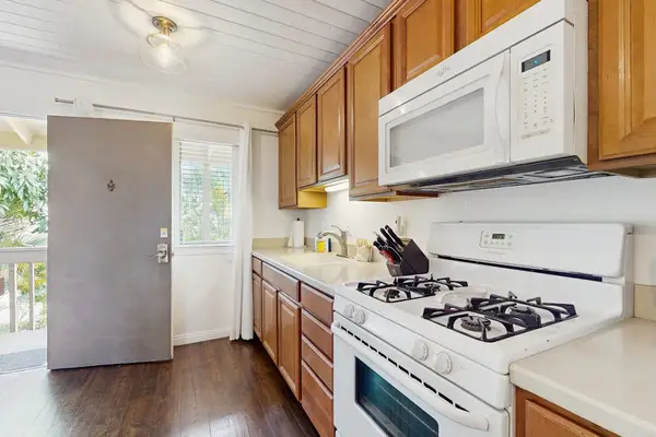 Bright Kitchen Layout with Gas Range, Overhead Microwave & Entry Access