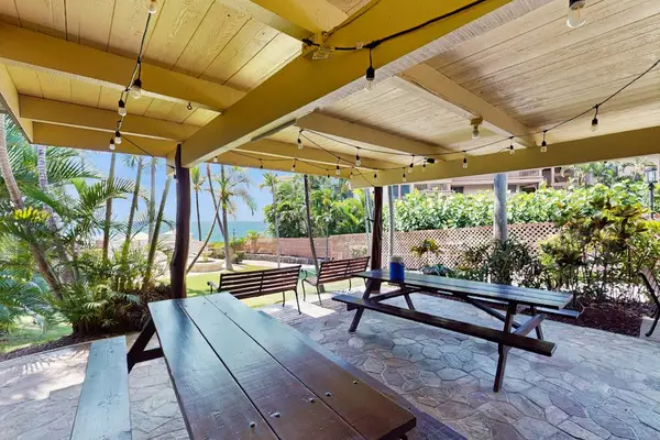 Covered Outdoor Pavilion with Wooden Picnic Tables & Overhead String Lights