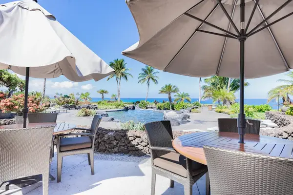 Patio Dining Tables with Umbrellas Overlooking Resort Pool & Ocean