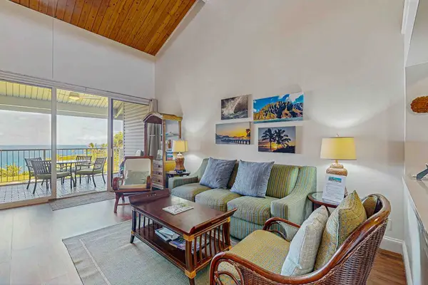 Living room with vaulted ceilings and natural light streaming in from the lanai.